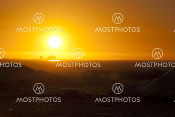 An orange sunset over the winter ocean.