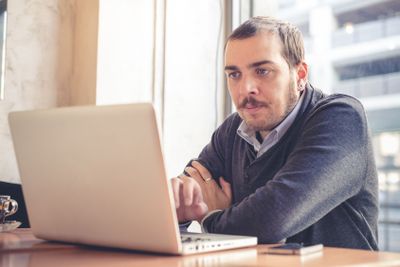 multitasking man using tablet, laptop and cellhpone