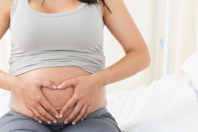 Pregnant woman making heart shape on her belly