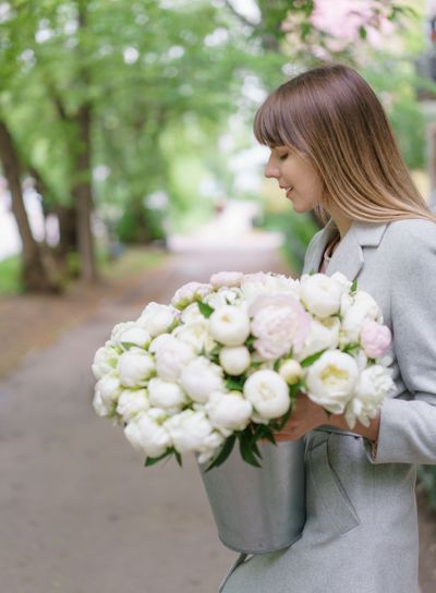 Beautiful bouquet of white peonies in woomans hands ....