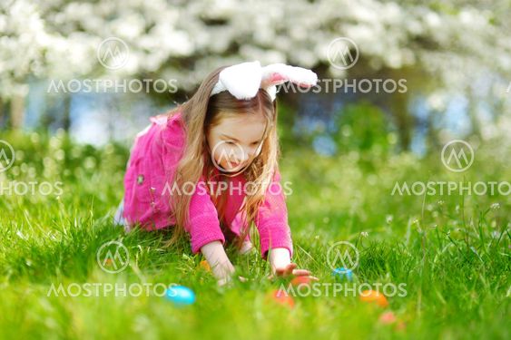 Adorable little girl hunting for easter egg on Easter day