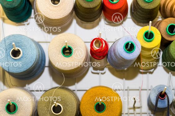 Bobbins with colorful threads on old wooden table...