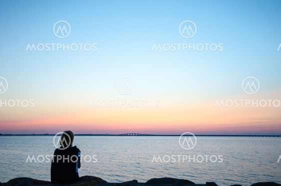 Woman watching bridge at sunset