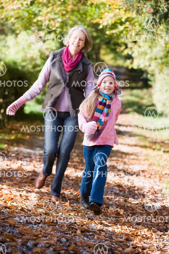 Grandmother and granddaughter playing in woods