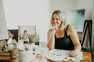Happy, painting and portrait of woman in studio at desk...