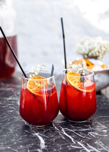 Close-up of two glasses with a berry cocktail on a black...