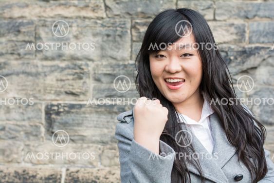 Successful woman by a stone wall