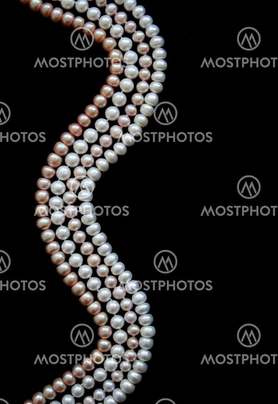 White, black and pink pearls on the black silk