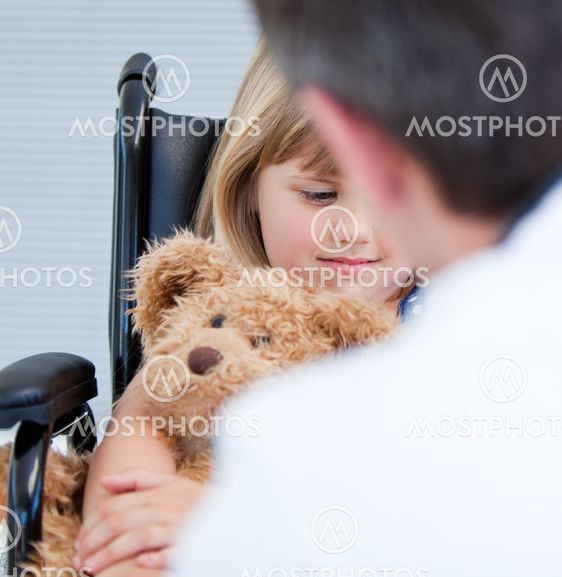 Male doctor talking with a disabled little girl