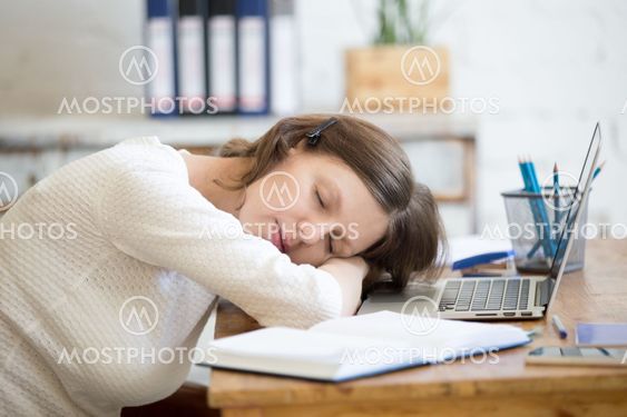 Young woman sleeping on office desk