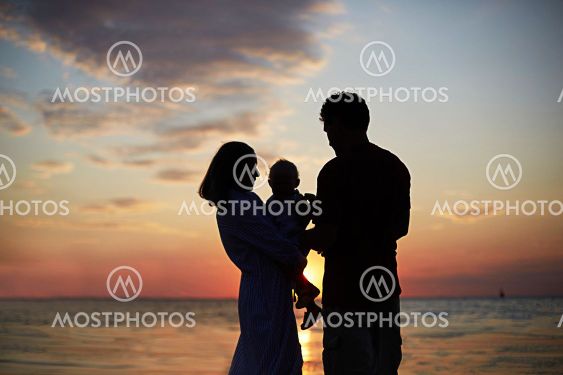 The silhouette of the family mom, dad child against the...