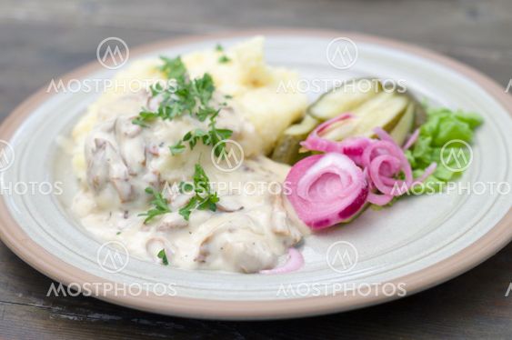 Mashed potatoes with creamy mushroom sauce and pickled red onions