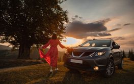 Woman near car. Sunset in the mountains