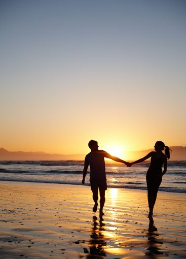 Couple, silhouette and holding hands at beach, sunset...