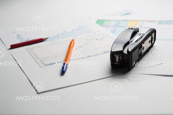 Business background with pen, pencil and stapler