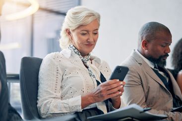 Business, waiting room and mature woman with phone,...
