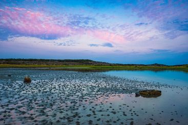 Coastal view in Sweden at dusk with serene waters...