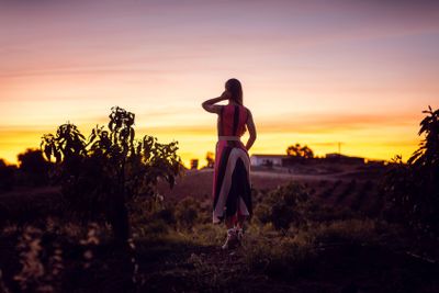 Woman watching the afterglow in an olive grove
