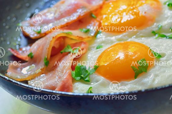 fried egg with bacon in a frying pan