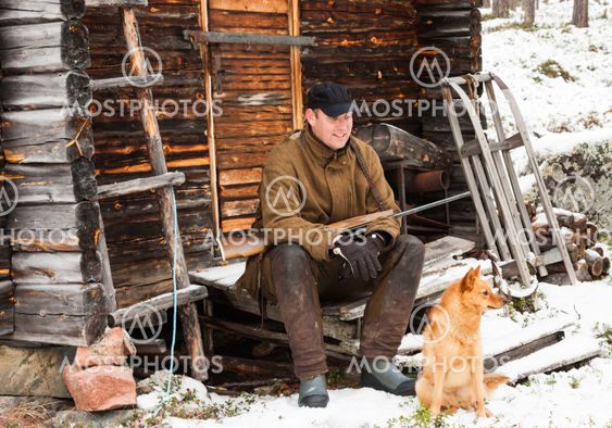 Hunter with his dog sitting outside his cottage