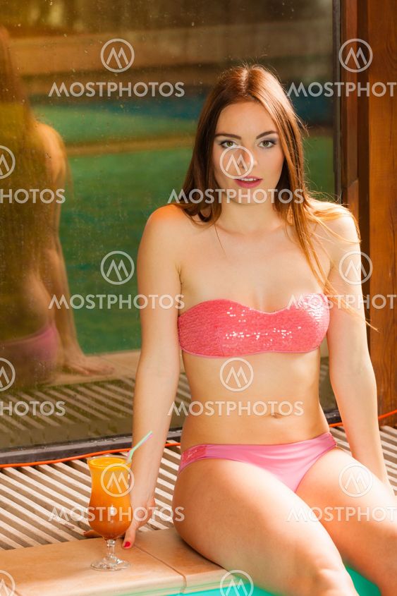 Woman relaxing at swimming pool edge. Leisure.