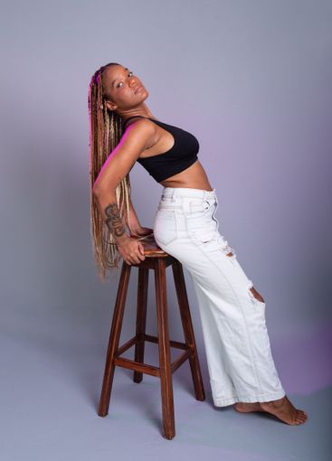 Brunette model with braids in her hair, wearing white...