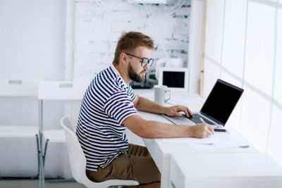 business man sitting at desk in office and looking at...