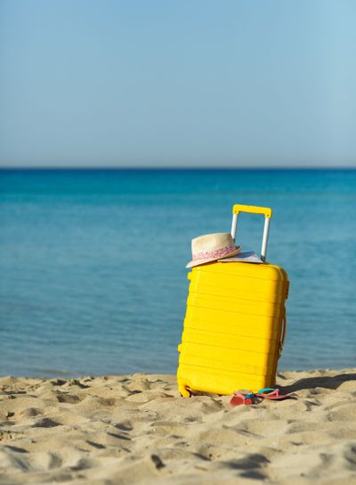 Travel holiday vacation suitcase with map, straw hat and...