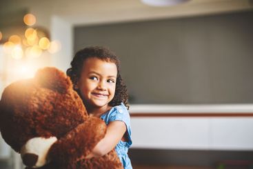 Happy, fun and child hugging teddy bear for playing,...