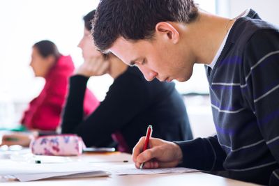 young, handsome male college student sitting in a...