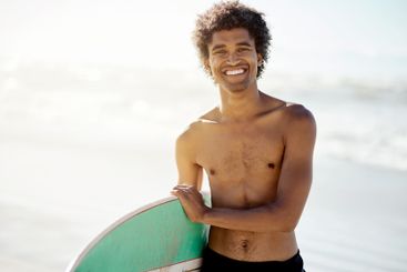 Portrait, man and happy with surfboard at beach, sea and...