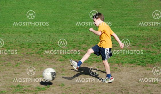 Boy kicking soccer ball