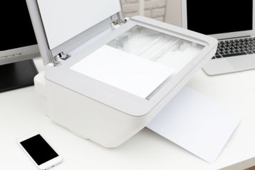 Home office workspace with scanner and computers on desk...