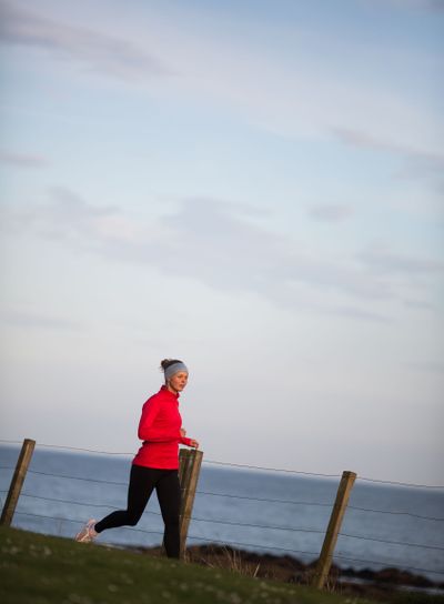 Young woman on her evening jog along the seacoast