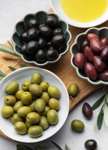 Variety of olives, olive oil, and olive branches served...
