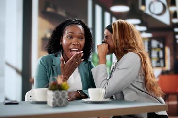 Black Businesswoman Sharing Gossip With Friend