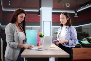 Smiling Retail Assistant Scans Clothes for Happy Customer