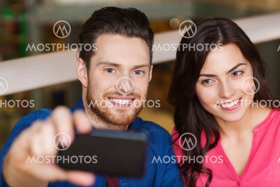 couple taking selfie by smartphone at restaurant
