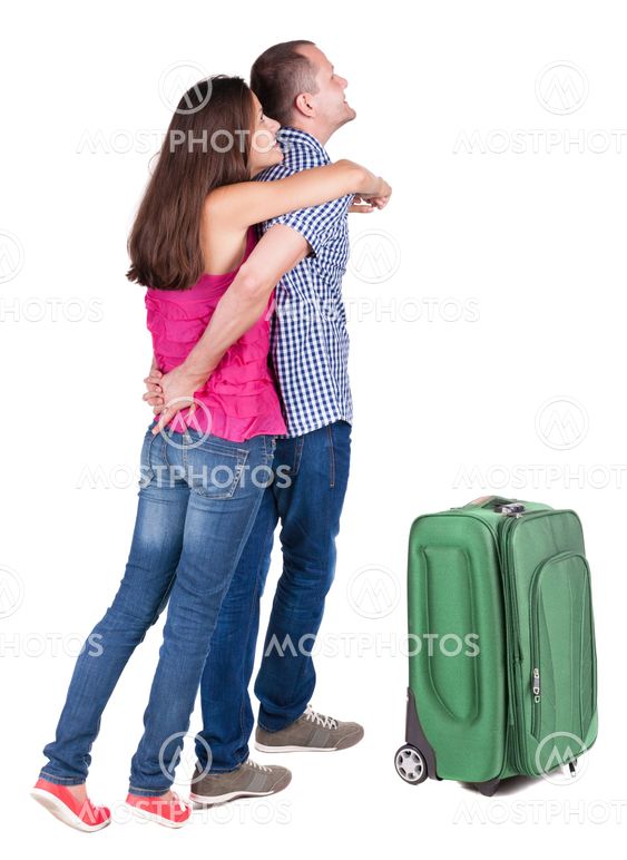 Back view of young couple traveling with suitcas .