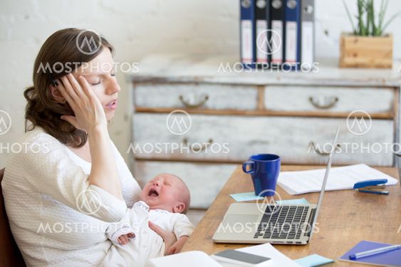 Portrait of young business mom having headache because of crying