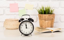 Reminder note and black old-fashioned alarm clock