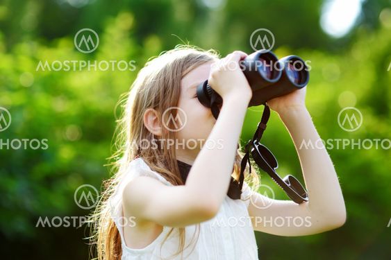 Funny little girl looking through binoculars