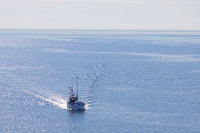 Small fishing boat on the blue sea heading back after...