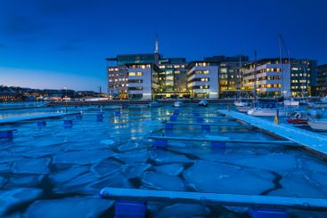 Dusk settling over icy harbor with offices in...