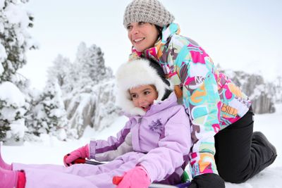Mother and daughter playing in the snow together