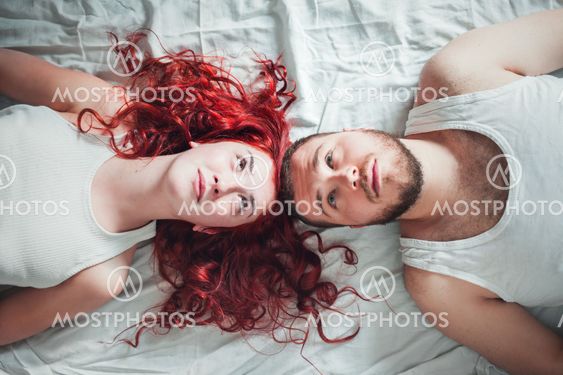 Top view of a happy couple heads to each other on white...