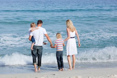 Happy family walking on the sand 
