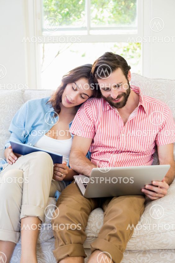 Couple using digital tablet and laptop