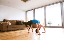 Young woman exercising at home, stretching, doing bridge pose.