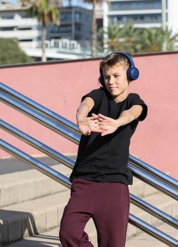 Handsome teenager standing with skateboard and listening...